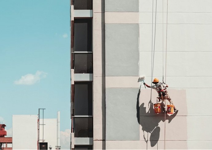 Europa 9: Especialista en trabajos verticales aplicando revestimientos protectores de alta durabilidad en una fachada valenciana.