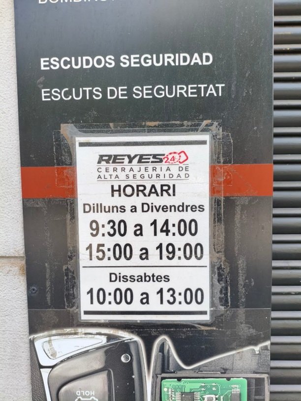 Placa identificativa con horario de atención al público y servicios de alta seguridad en local físico de Sabadell.